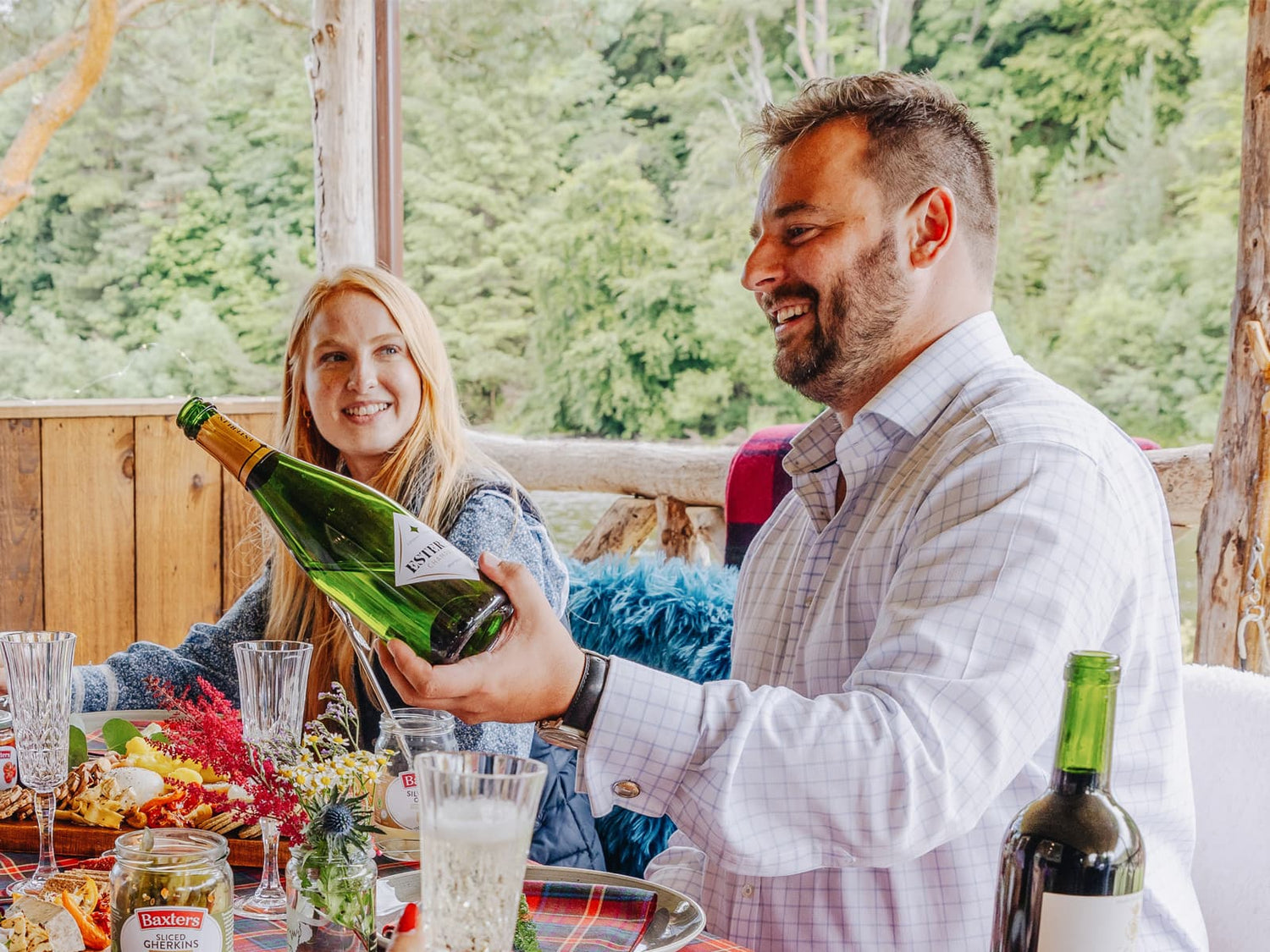 A Couple opening a valentines food hamper and sharing champagne
